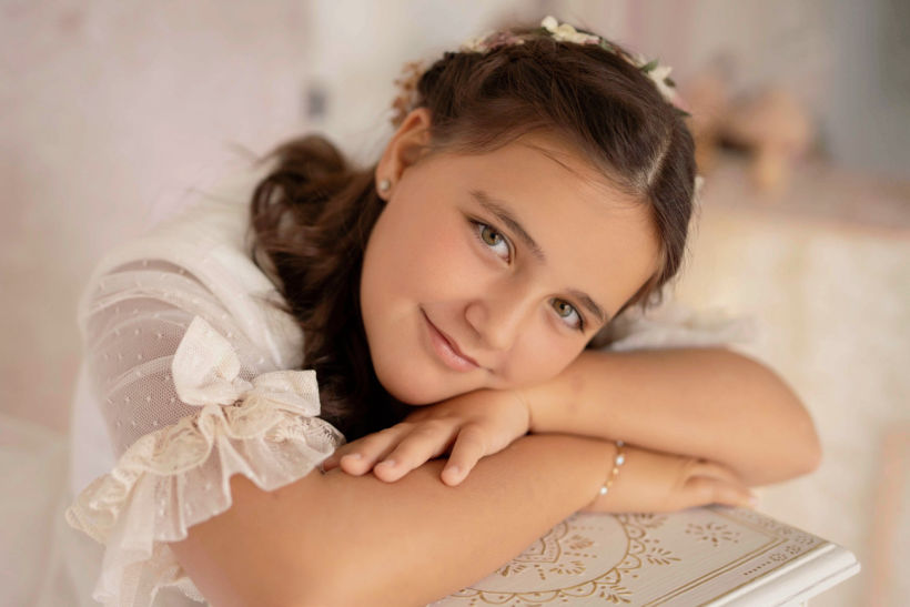 Las sesiones pueden realizarse en estudio o en exteriores, según el estilo que más os guste. En el estudio trabajo con fondos y luz suave para lograr imágenes elegantes y atemporales. En exteriores, aprovecho espacios naturales y urbanos que aportan movimiento, luz y un toque más espontáneo al reportaje.  Cada temporada preparo nuevos escenarios, atrezzo y detalles para que cada reportaje sea único y personalizado. Me adapto al ritmo de cada niño, respetando sus tiempos y su forma de expresarse, para que la sesión sea una experiencia agradable y divertida.  También ofrezco álbumes y productos personalizados, pensados para que tengáis un recuerdo completo y cuidado de esta etapa tan importante. Porque la comunión no es solo un evento, es un recuerdo que acompañará a vuestros hijos durante toda la vida.